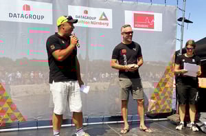 Moderatoren und Teilnehmende bei der Siegerehrung auf der Bühne des DATAGROUP Triathlon Nürnberg.