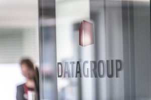 DATAGROUP Logo auf einer Glastür im Bürogebäude des Standorts Ibbenbüren.