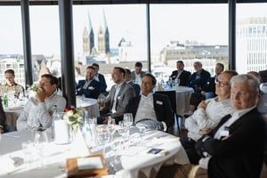 Teilnehmerinnen und Teilnehmer des Business Sunset Dinner von DATAGROUP in Bremen mit Blick auf die Bremer Altstadt und den St. Petri Dom.