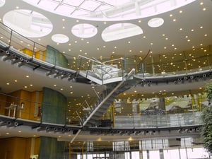 Atrium im DATAGROUP Hauptsitz Pliezhausen mit kreisförmigen Oberlichtern, offener Galerie und moderner Treppe.