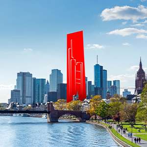 Blick auf die Frankfurter Skyline mit Hochhäusern des Bankenviertels, dem Main im Vordergrund und einer stilisierten roten Wolkenkratzer-Silhouette unter bewölktem Himmel